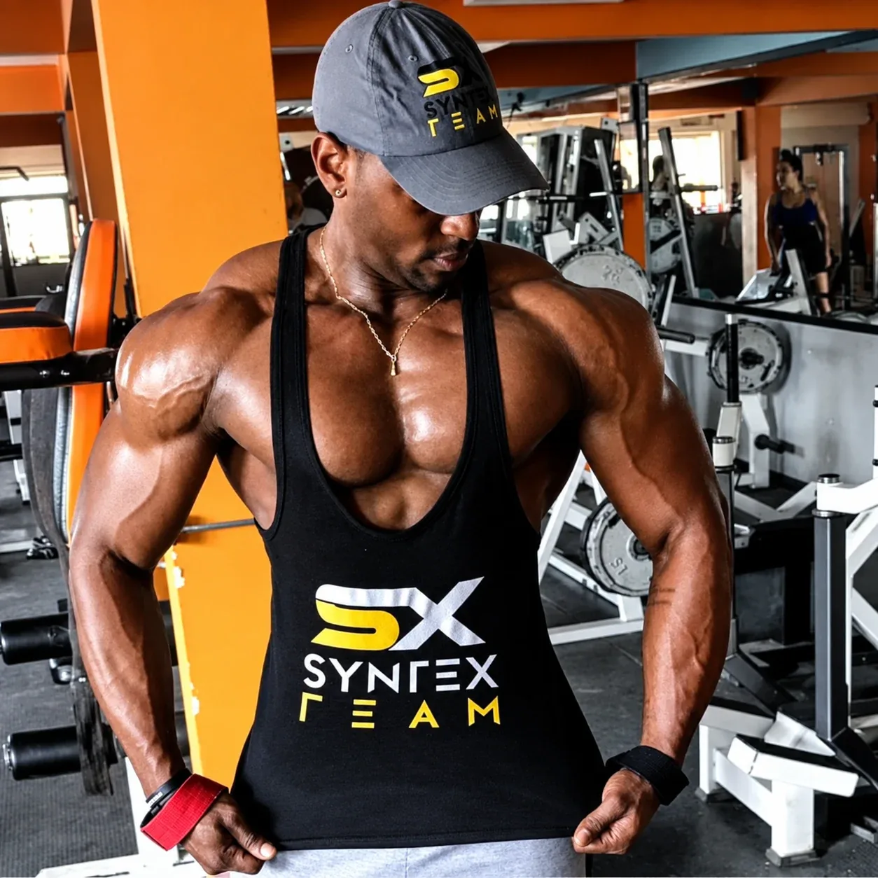 Syntex Team athlete in a grey cap and a black SX Syntex Team tank top at the gym